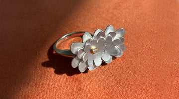 handmade diamond ring shown on orange velvet background