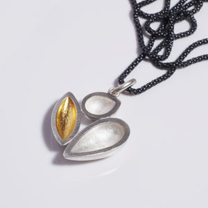 sterling silver pendant with three elements, one of which has 24k gold keum boo, hanging from an oxidised chain